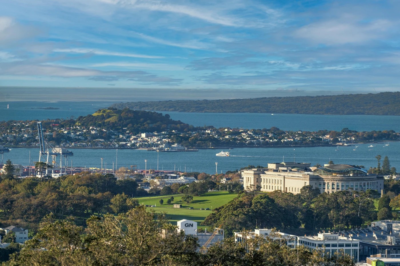 Auckland Museum and the city overlooking Waitematā Harbour, with a ferry crossing toward Devonport